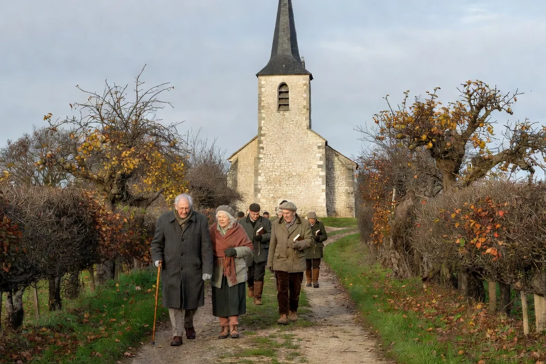Clocher d'église rural du Pays de Bray en pierre de craie, paroissiens se rendant à la messe dominicale